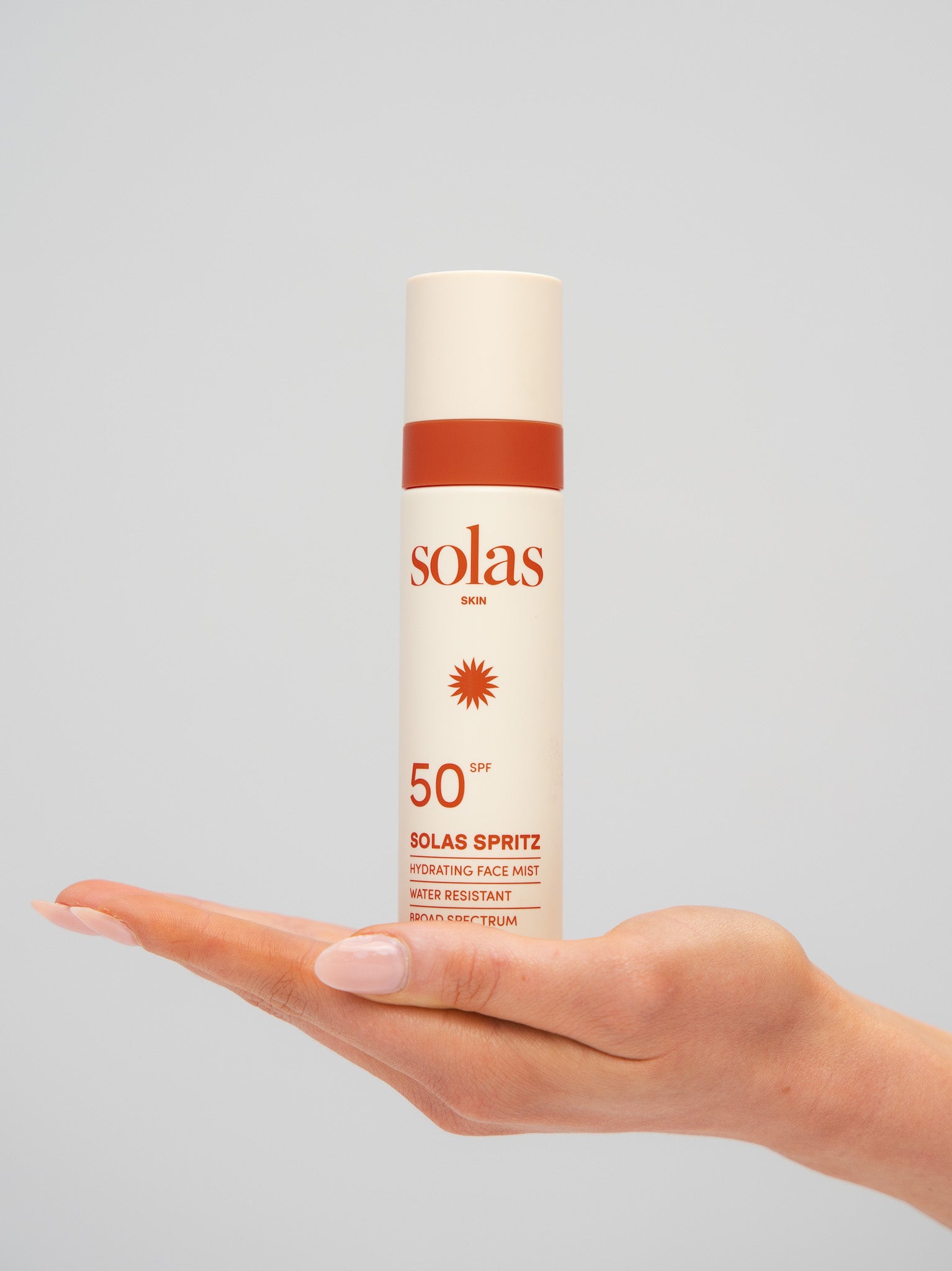 Solas Spritz product held in a hand against a grey background