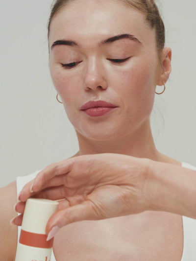 Woman applying Solas Spritz to face.